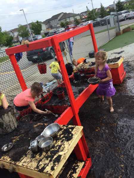 children playing in a mud kitchen on mud day